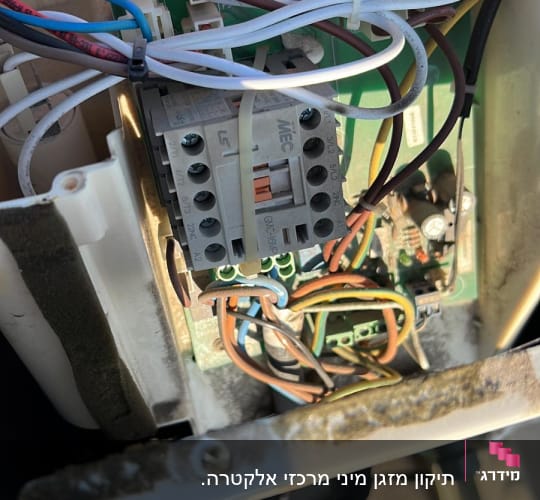 לוח חשמל עם חוטים צבעוניים ומחברים במזגן
